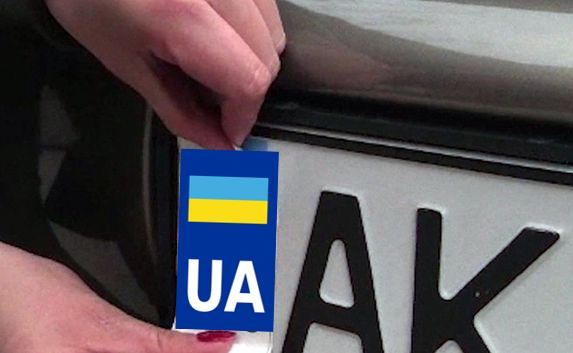 Неизвестный портит номера авто наклейкой с флагом Украины