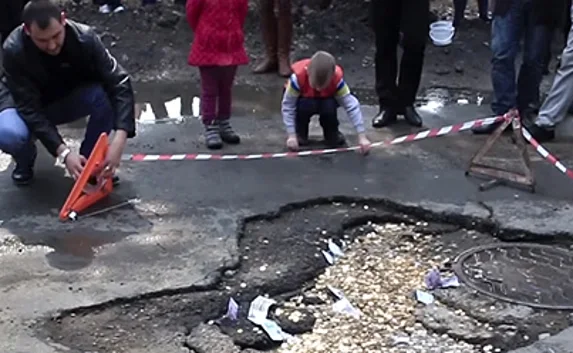 В Приморье дорожную яму засыпали деньгами
